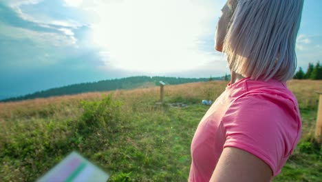 Sportliche-Frau,-Die-Auf-Der-Spitze-Des-Hügels-Steht-Und-Bei-Sonnenuntergang-Den-Himmel-Betrachtet