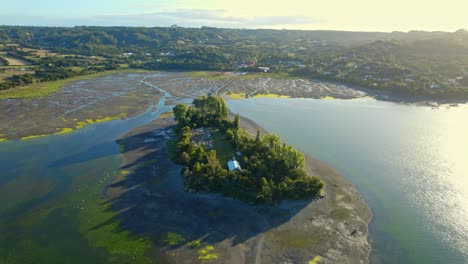 Drone-Sobrevolando-La-Isla-Aucar,-Con-Vistas-A-Un-Cementerio-Y-Una-Capilla,-En-La-Soleada-Chiloé.