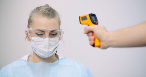 doctor measuring patient temperature at health care clinic 9