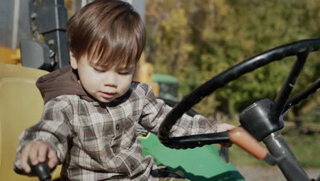 a small tractor driver at the wheel of a tractor, intensively turns the steering wheel and pulls the lever