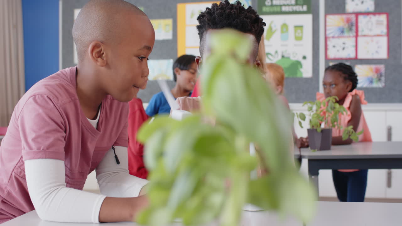 In school, children collaborating on science project with plants in classroom