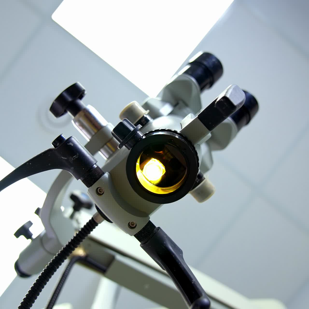Modern enabled microscope in a lab. Scientific equipment for coronavirus testing in the laboratory. Microbiology concept. View from below on bright light from microscope