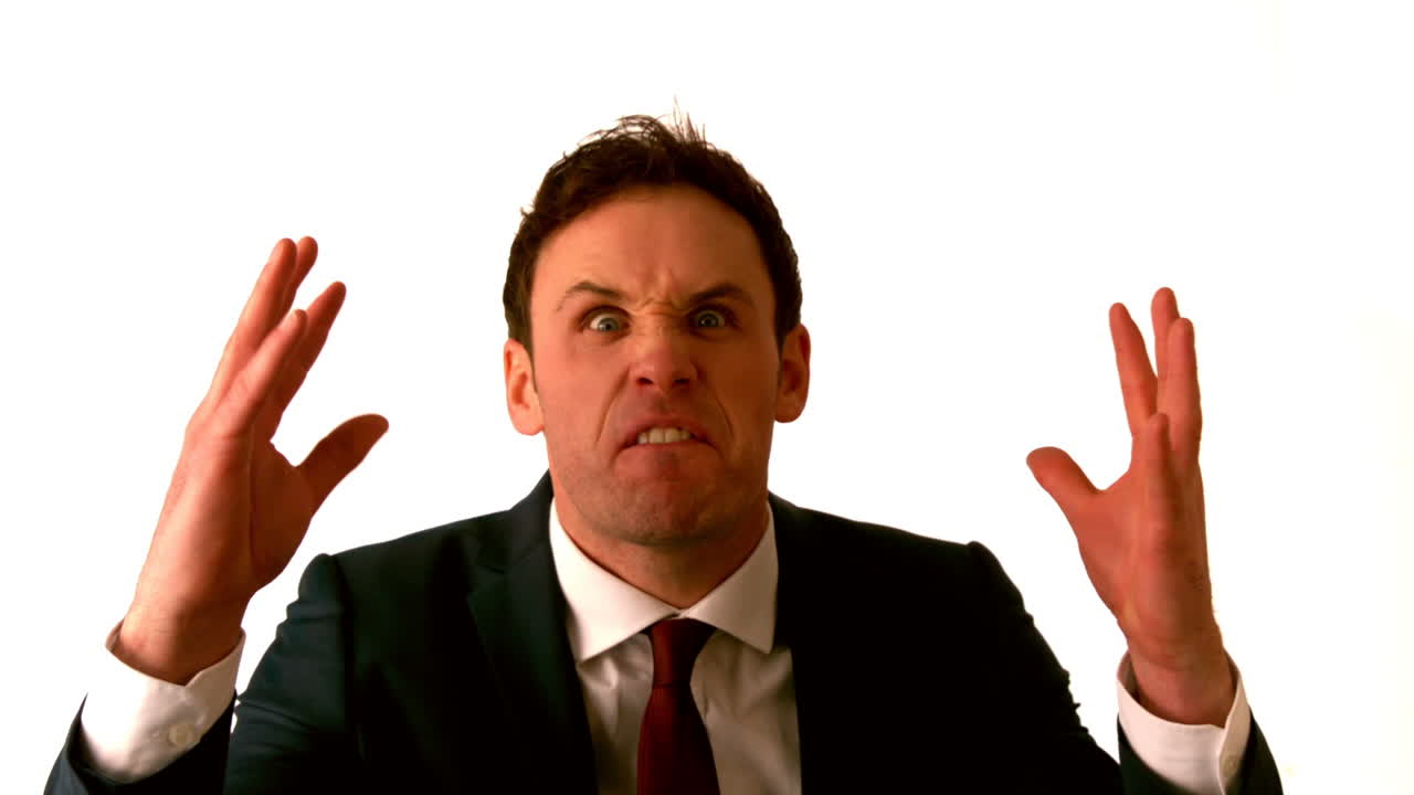 un hombre de negocios enojado gritando a la cámara.