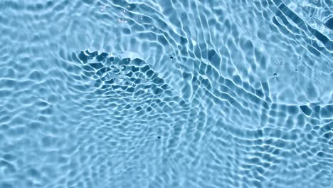 water surface texture top view. water splash blue colored. pure blue water with reflections sunlight and shadows in slow motion. motion clean swimming pool ripples and wave. 4k