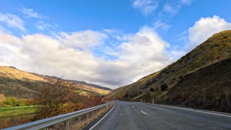 a 30-second drive through wanaka's stunning mountain roads under clear blue skies and vibrant autumn foliage