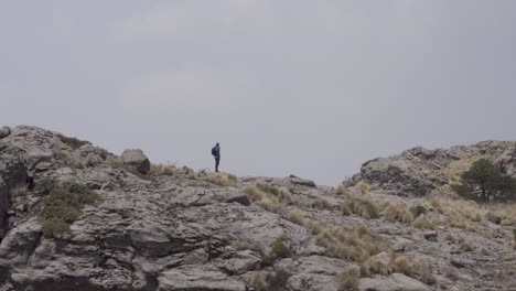 hispanic hiker on top of mount tlaloc under a cloudy sky in mexico