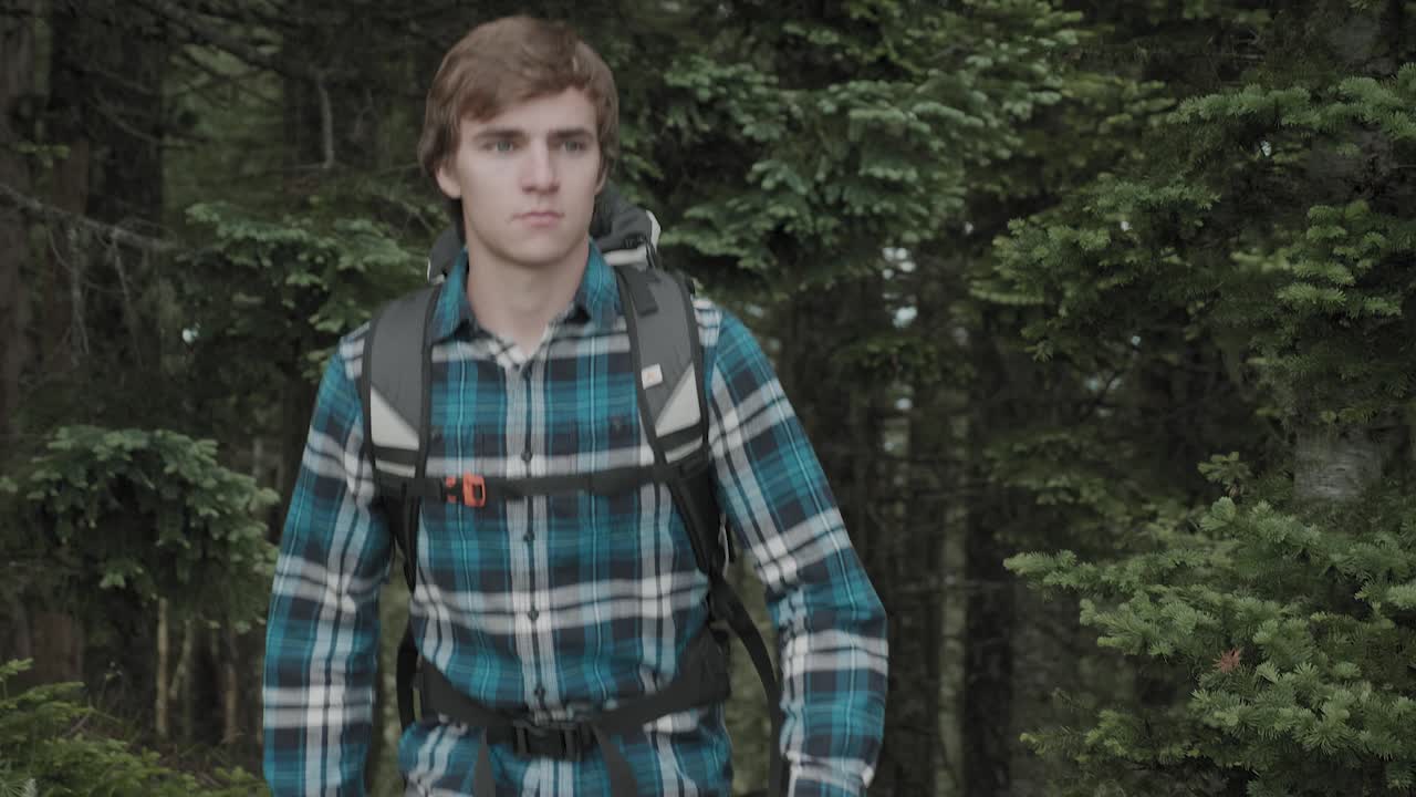 White male hiking outdoors on trail up peaceful lush high elevation green forest in the pacific northwest in Oregon