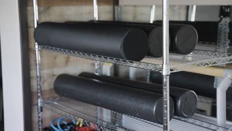 Foam-rollers-are-tidily-organized-on-the-shelf-within-the-gym