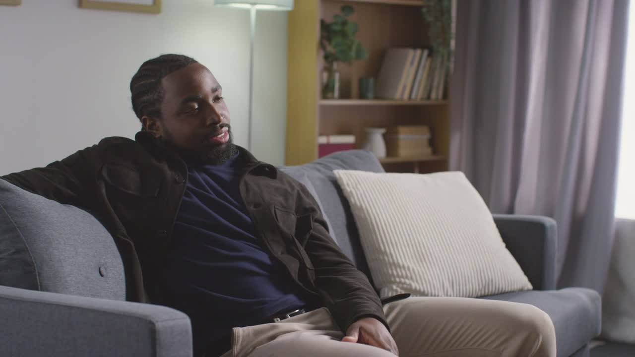 Portrait Of Smiling Young Man Relaxing At Home Sitting On Sofa 1