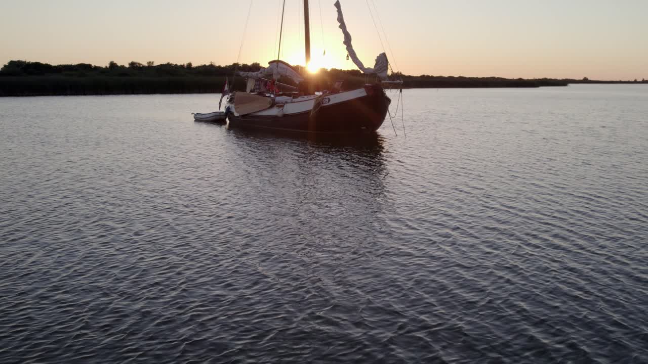 Vista aerea di yacht ormeggiati sull'IJsselmeer al tramonto a Makkum, Paesi Bassi, con una splendida illuminazione al tramonto, atmosfera serena, riprese drone di alta qualità che mostrano paesaggi mozzafiato.