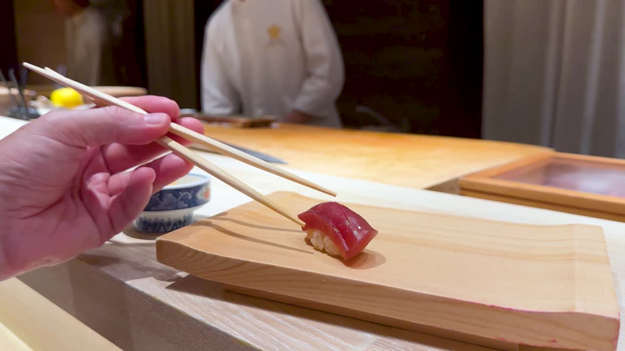 Šéfkuchař připravuje a servíruje sushi s hůlkami