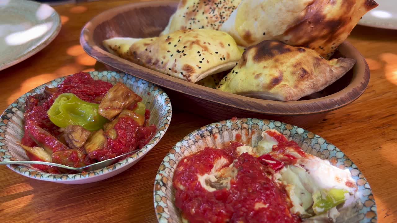 platos tradicionales turcos de meze con pan pide ekmek fresco en pavo de bodrum, auténticos y sabrosos entrantes de berenjena, tiro de 4k
