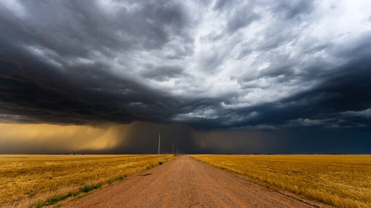 Down a dusty road as powerful storm clouds bring heavy rain and lightning