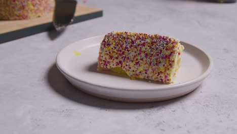 immagine ravvicinata di una fetta tagliata dalla torta di celebrazione arcobaleno sul piatto