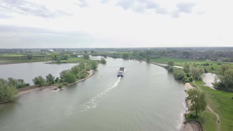 aerial footage of the cargo ship on the river going away to the destination