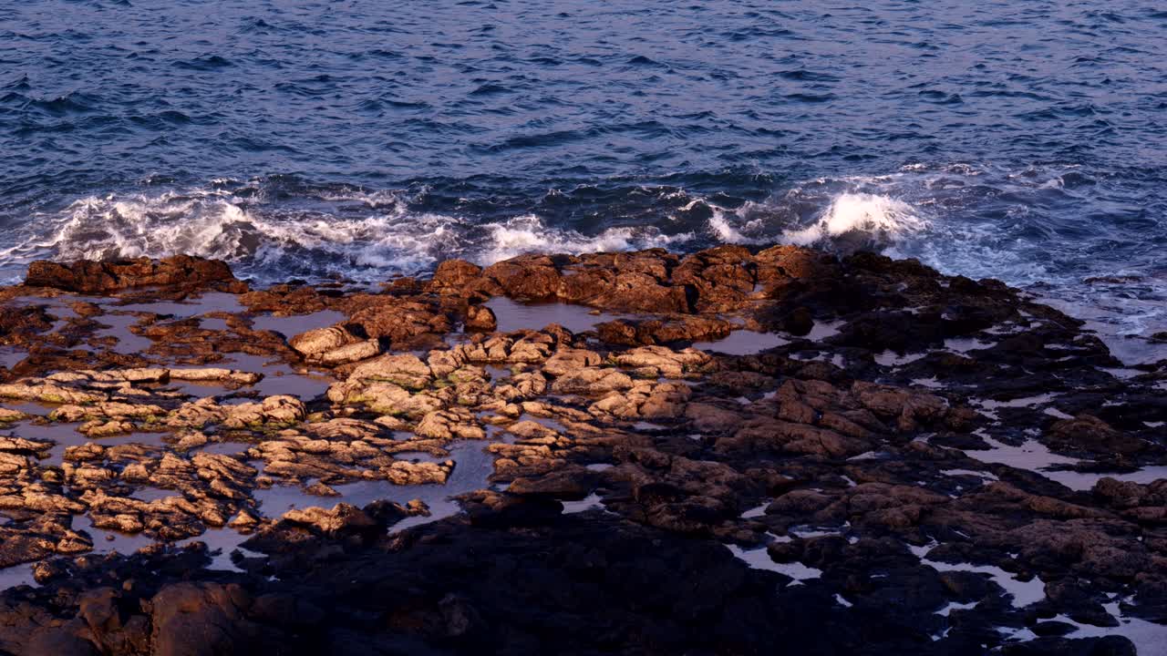Onde dell'oceano che si infrangono dolcemente su una costa rocciosa