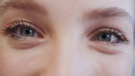 Close-up-of-the-blue-eyes-of-a-smiling-caucasian-female-nurse,-in-slow-motion