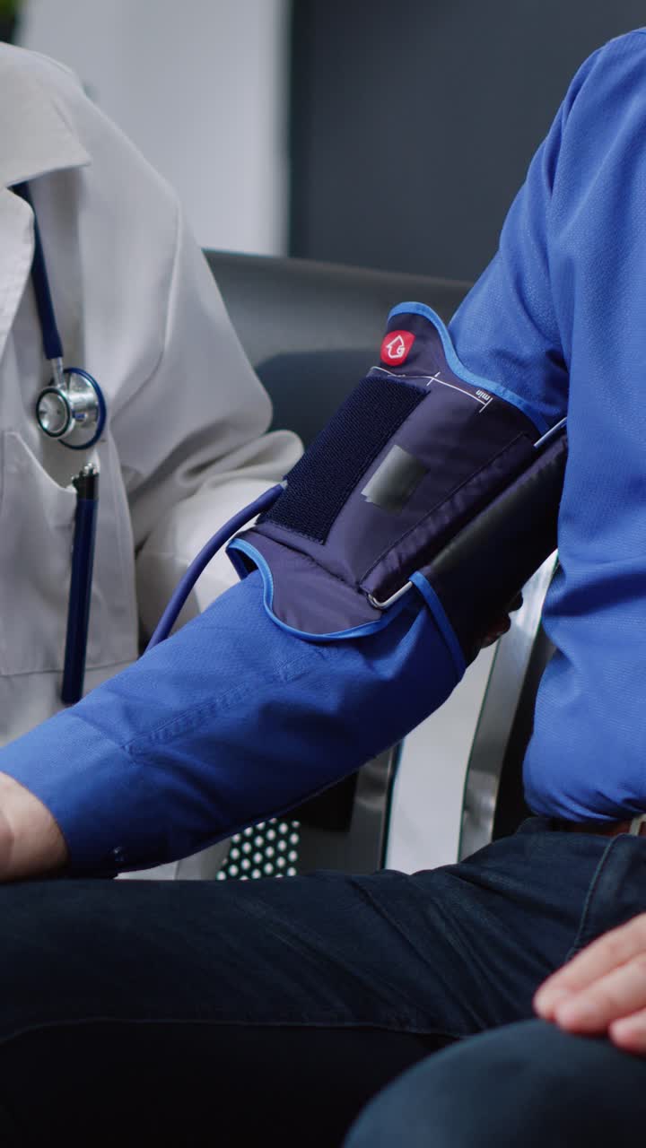 Video verticale: medico anziano misura l'ipertensione di un uomo