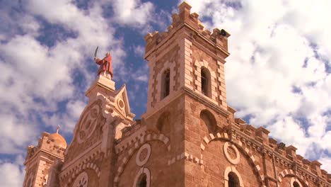 a time lapse pull back as clouds drift over a catholic maronite church