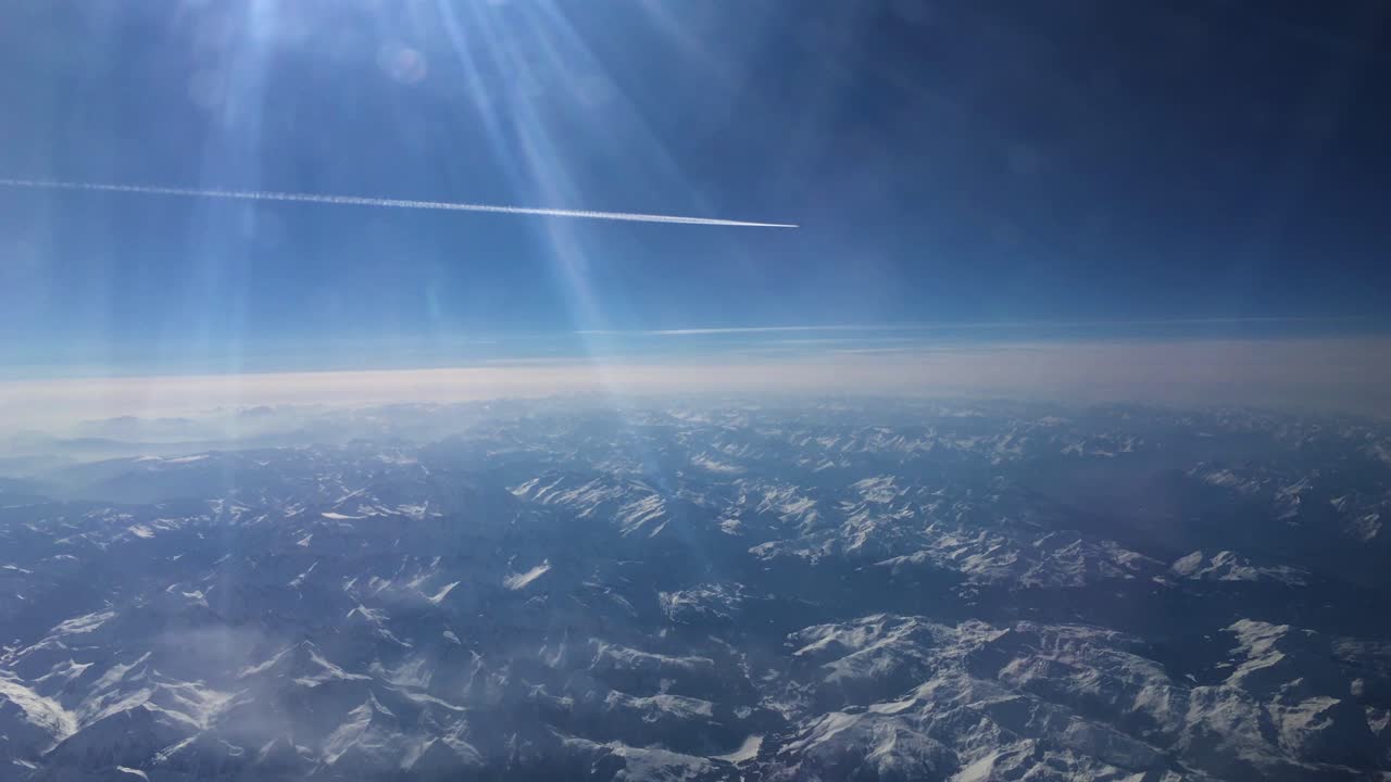 멀리 날아가는 비행기 흰색 흔적과 유럽의 알프스 위에서 눈 덮인 산을 보여주는 비행기 영상 2