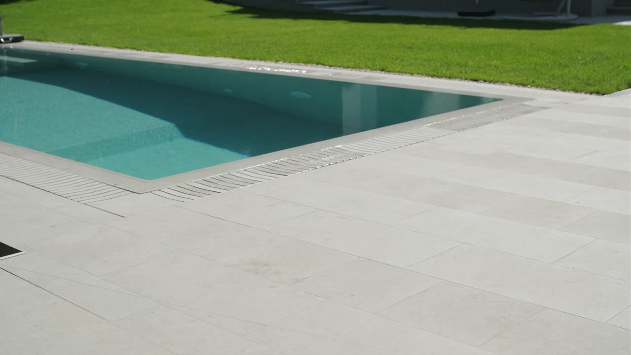 Swimming pool with tile deck and grass lawn