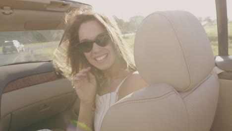 mujer feliz disfrutando de un viaje por carretera en un descapotable