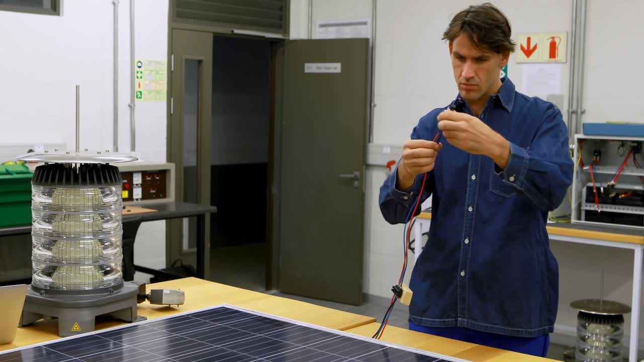 Male worker working on solar panel in office 4k