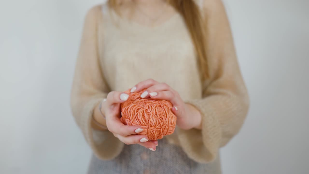 young woman rolls up threads for knitting