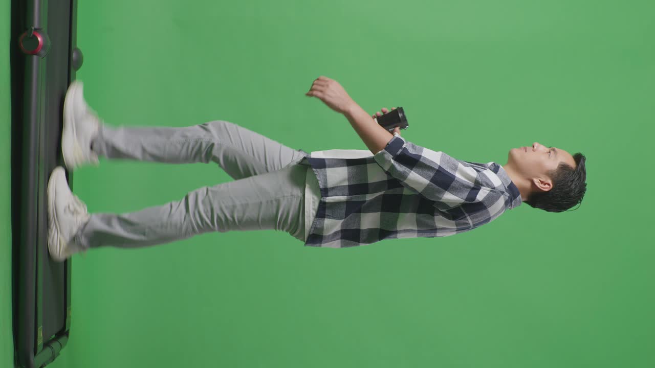 동양인 남성의 전체 신체가 녹색 화면 배경에서 고 커피를 마시고 있습니다.