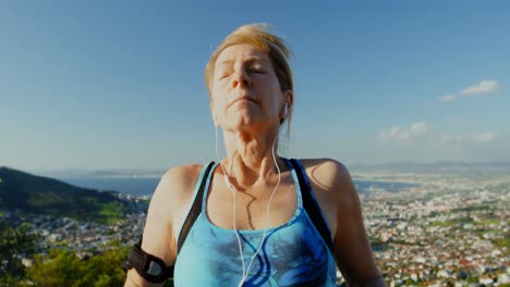 mujer mayor escuchando música en auriculares en el campo 4k