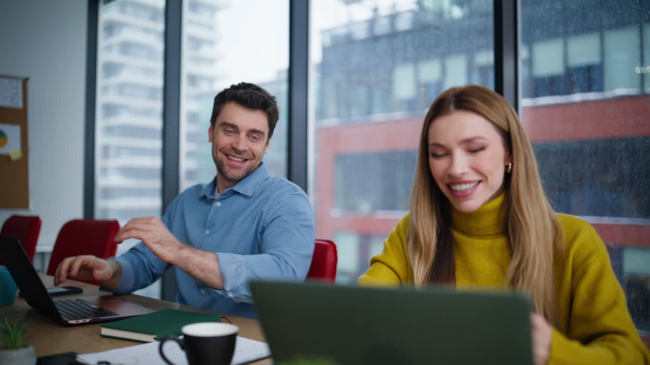 Friendly colleagues enjoying teamwork looking laptop at office space closeup