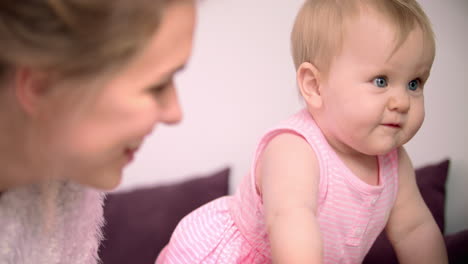 child learning to walk with mother. beautiful infant girl crawling at home