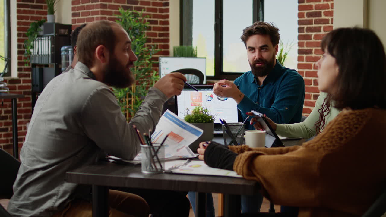 Business manager analyzing charts on laptop and working with colleagues