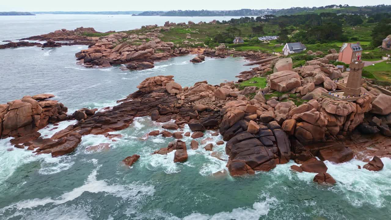 Waves crashing against granite rocks on untamed coastal near the Men Ruz lighthouse at Côte de Granit Rose, Ploumanac'h, Brittany, France