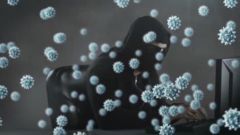 Animation-of-of-macro-covid19-cells-over-man-wearing-balaclava,-using-a-laptop