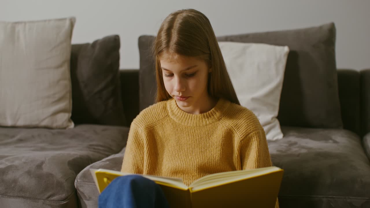 chica haciendo la tarea en el sofá