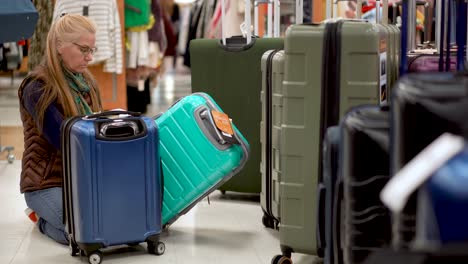 woman looking at luggage in a hypermarket