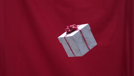 Christmas-present-tossed-into-the-air-red-background