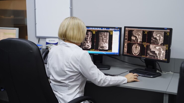 Medico che esamina immagini mediche su monitor di computer