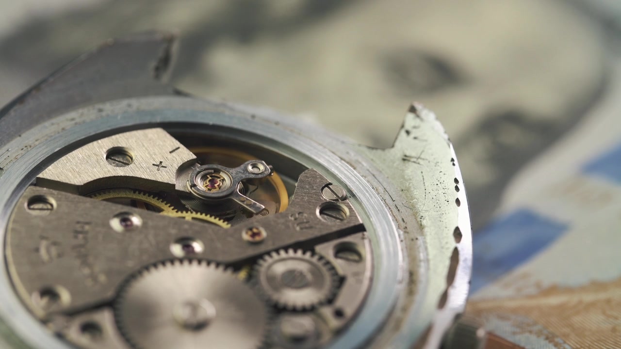 Close-up of a Working Mechanical Watch Movement with a Dollar Bill in Background