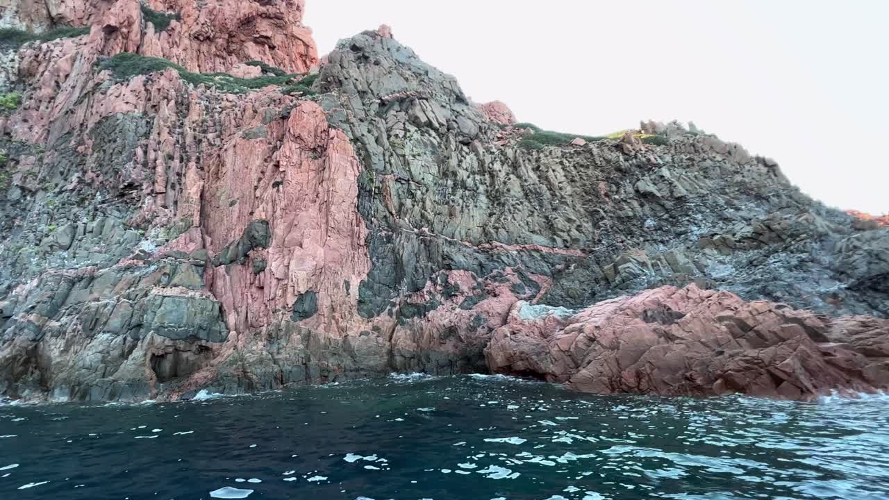Impressionanti formazioni rocciose vulcaniche delle Calanques de Piana sull'isola della Corsica, viste da una barca in movimento nella stagione estiva, Francia.
