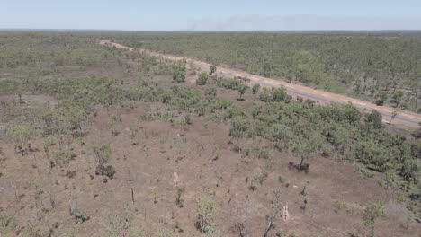 Toma-Aérea-De-Drones-En-Movimiento-De-Un-Automóvil-Que-Conduce-Por-Una-Carretera-Larga-Y-Recta,-Territorio-Del-Norte