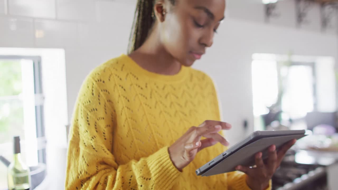 African american woman using tablet in kitchen