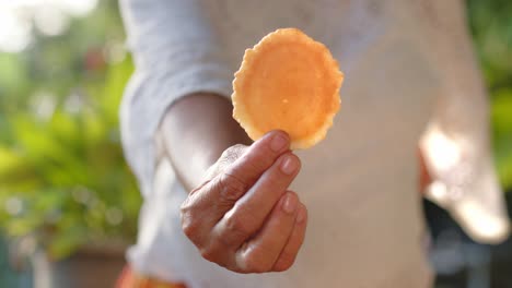 persona con una deliciosa galleta de manioc, vista delantera de cerca