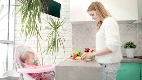 Madre-Cocinando-Para-Bebé-En-La-Cocina.-Mujer-Cocinando-Con-Hija-En-Bebé