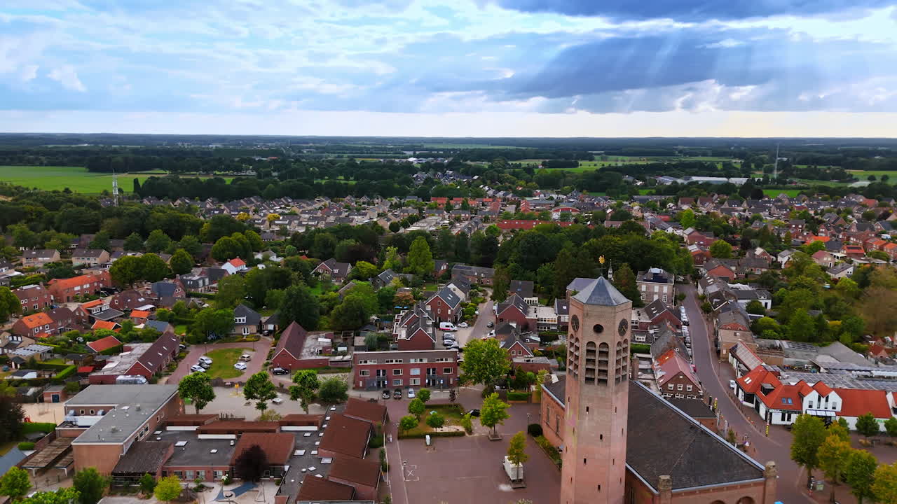 Aerial view of a Dutch town with church tower. Panoramic drone view of a small Dutch town with a historic church tower and surrounding green fields