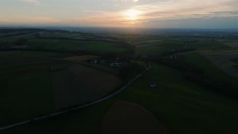 sunset view with warm light glowing over fields, roads, and distant farms in kurnberg, austria. aerial elevated view