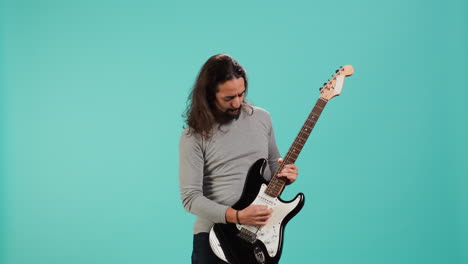 man with long hair performing metal songs on guitar