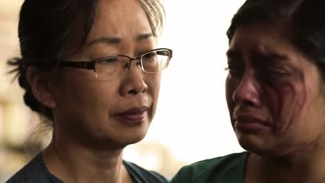 a mother comforts her daughter who appears distressed, showcasing a powerful moment of emotional connection and support between them amid adversity.