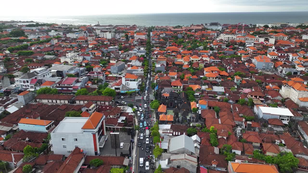 Busy road to Kuta Beach in Bali, aerial view cityscape with the buildings, Indonesia.